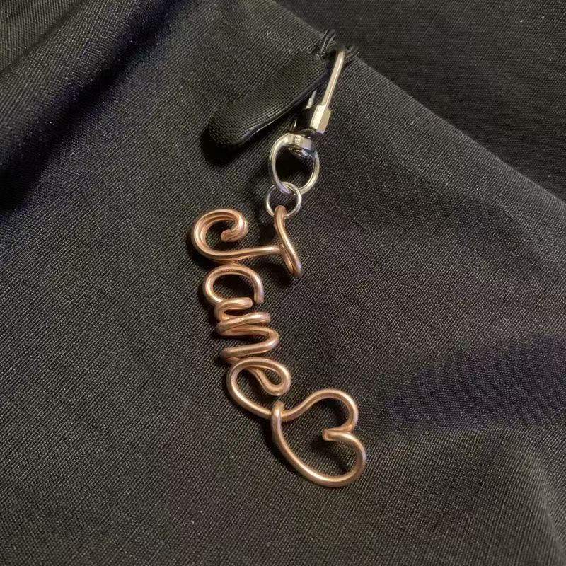 Personalized hand-bent wire name pendant with custom alphabet letter charm, suitable for bags, phones, or keychains.