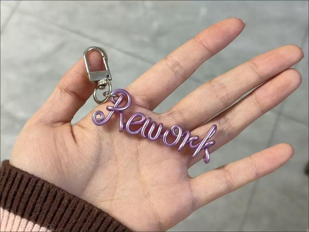 Personalized hand-bent wire name pendant with custom alphabet letter charm, suitable for bags, phones, or keychains.