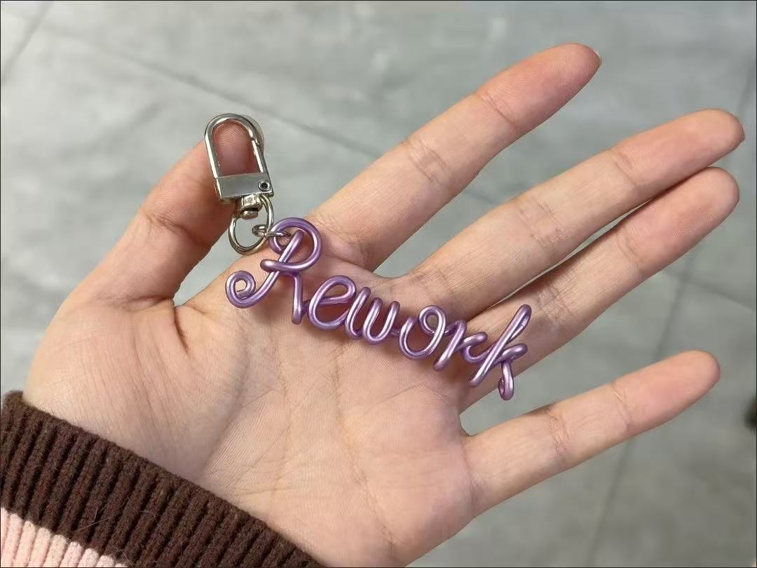 Personalized hand-bent wire name pendant with custom alphabet letter charm, suitable for bags, phones, or keychains.